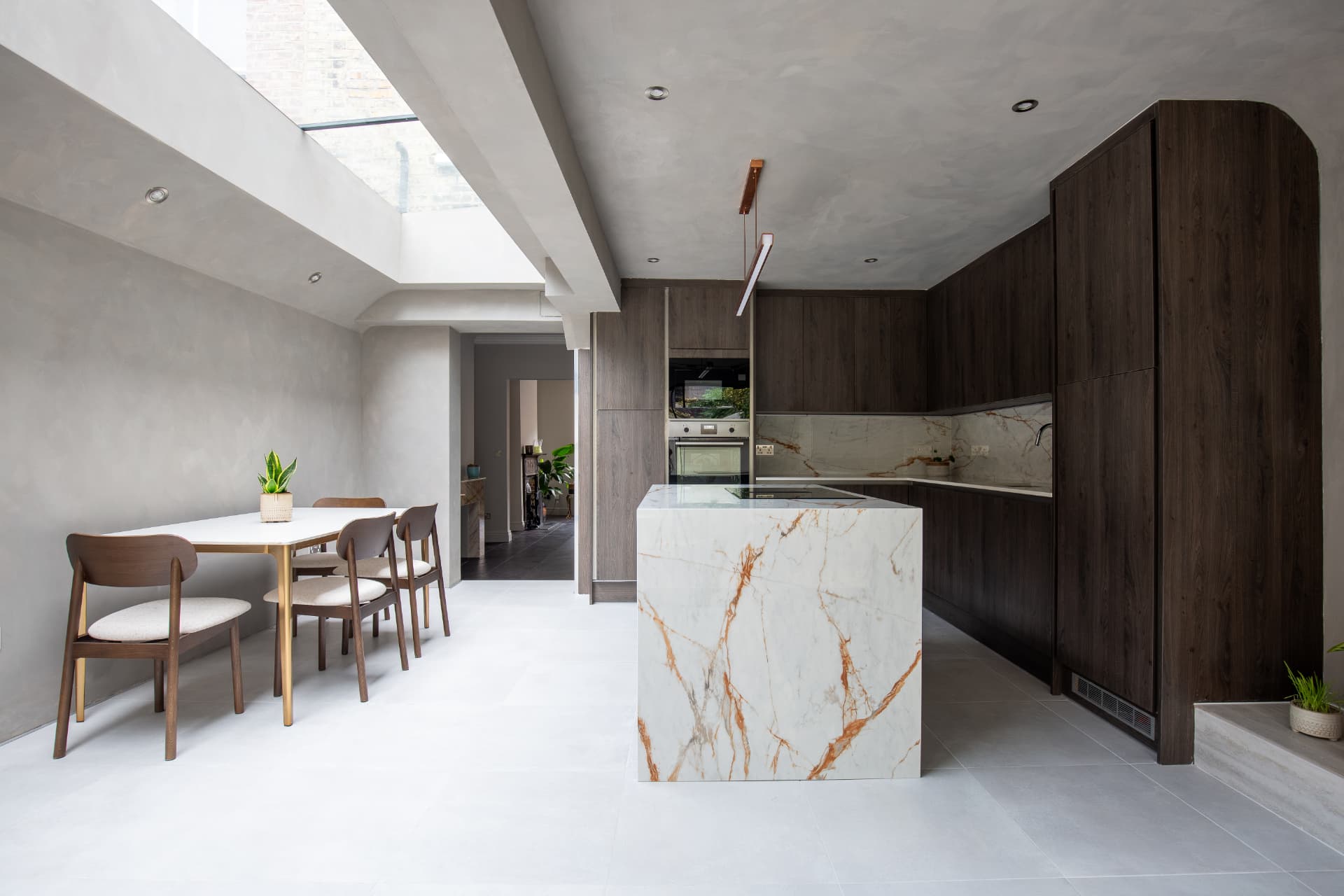 Kitchen extension with marble island and dining area under a skylight